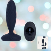 A navy blue silicone personal massager, known as the Svakom Jordan Vibrating Anal Stimulator, is showcased against a backdrop of soft, blurred pastel lights. Accompanying it is a wireless controller and the sleek packaging, emphasizing its customizable thrusting and vibrating features via the SVAKOM App.